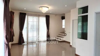 Spacious living room with elegant chandelier and large windows