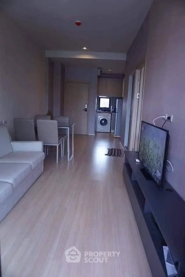 Modern living room with open layout and washing machine in compact apartment