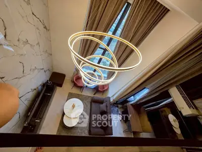 Luxurious modern living room with high ceilings and elegant lighting fixture