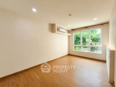 Spacious empty room with large windows and wooden flooring, perfect for customization.