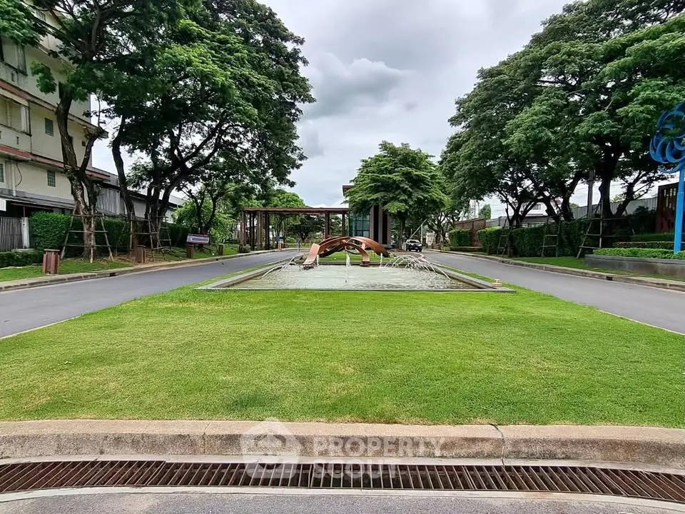 Elegant entrance with lush greenery and modern fountain feature.