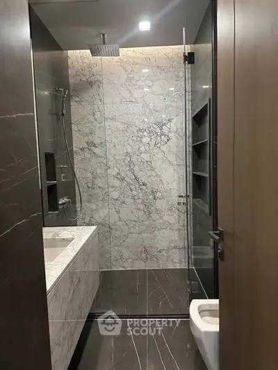 Luxurious modern bathroom with marble finishes and glass shower enclosure