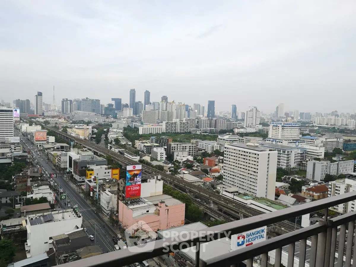 Stunning cityscape view from a high-rise balcony overlooking urban skyline and bustling streets.
