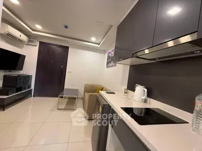 Modern living room with sleek kitchen and stylish furniture in a contemporary apartment.