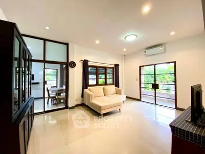 Spacious living room with modern decor and large windows offering natural light.