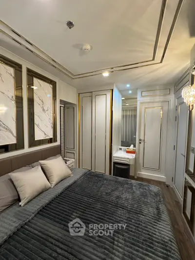 Luxurious bedroom with elegant decor and plush bedding in modern apartment.