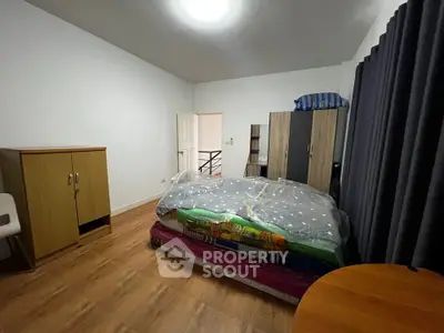 Spacious bedroom with modern furniture and wooden flooring