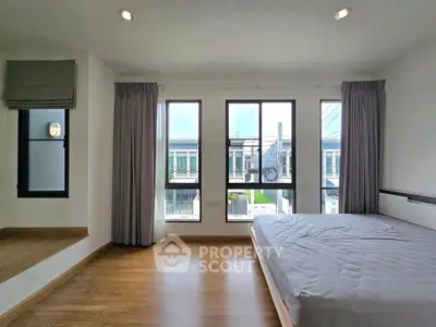 Spacious bedroom with large windows and modern design in a contemporary home.