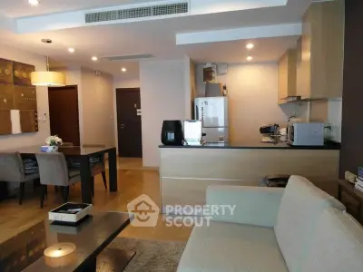 Modern open-plan living room and kitchen with stylish decor and dining area.