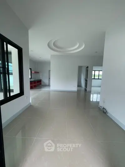 Spacious modern interior with sleek tile flooring and unique ceiling design, perfect for customization.