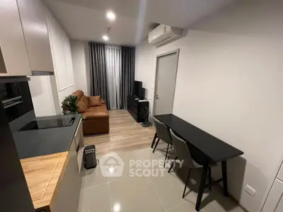 Modern living room with sleek furniture and open kitchen layout in a stylish apartment.