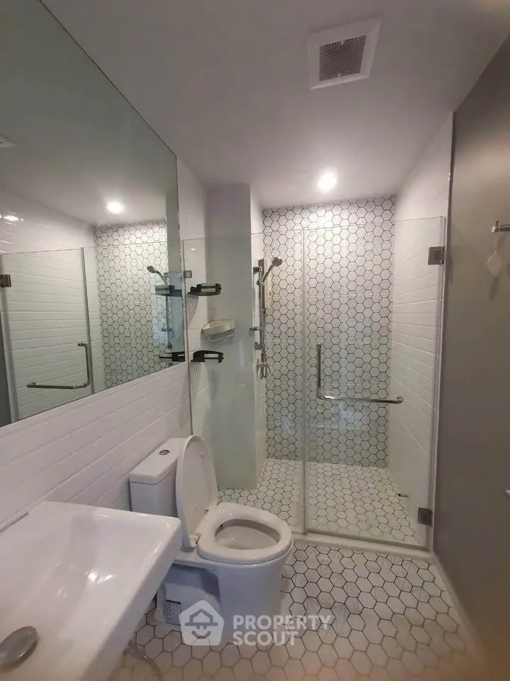 Modern bathroom with glass shower and hexagonal tile flooring