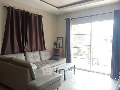 Spacious living room with modern sofa and large window for natural light.