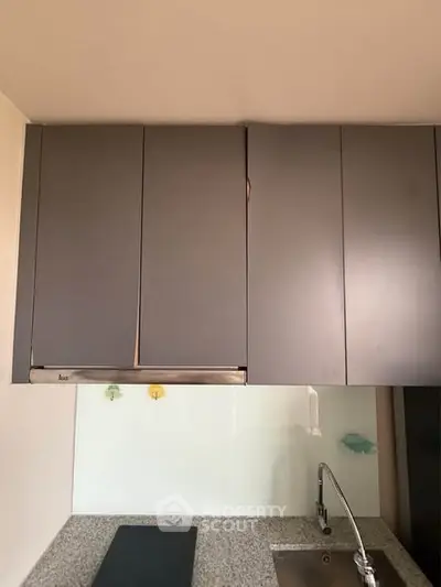 Modern kitchen with sleek cabinets and stainless steel sink, perfect for contemporary living.