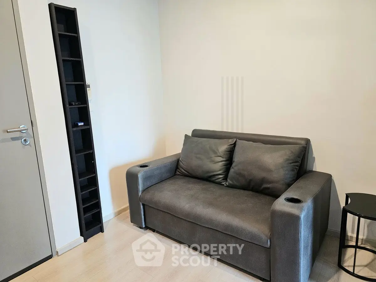 Cozy living room with modern gray sofa and sleek shelving unit, perfect for urban living.