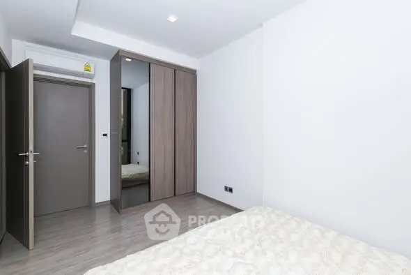 Modern minimalist bedroom with sleek wardrobe and neutral tones