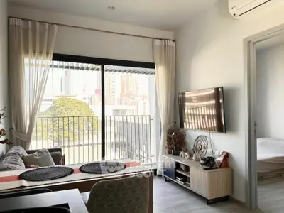 Modern living room with city view, stylish decor, and wall-mounted TV in a cozy apartment.