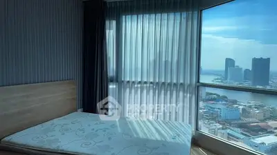 Stunning bedroom with panoramic city view and floor-to-ceiling windows.