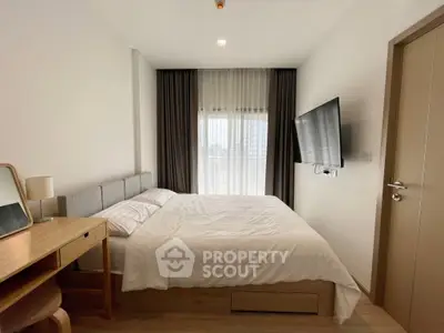 Modern bedroom with sleek design, featuring a wall-mounted TV and elegant furnishings, perfect for urban living.