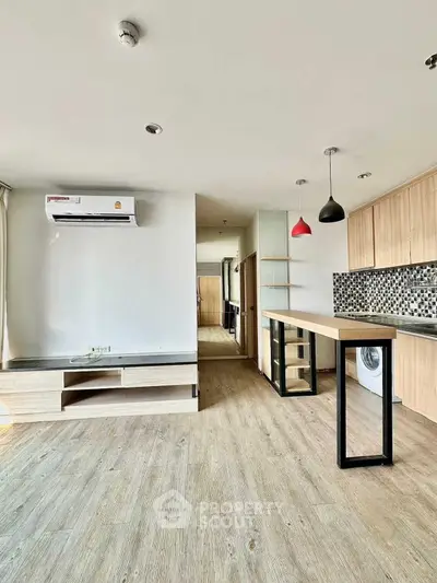 Modern open-plan kitchen with stylish lighting and wooden flooring