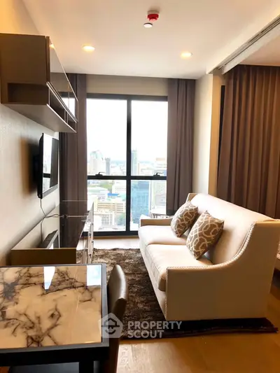 Modern living room with city view, elegant sofa, and stylish decor in high-rise apartment.