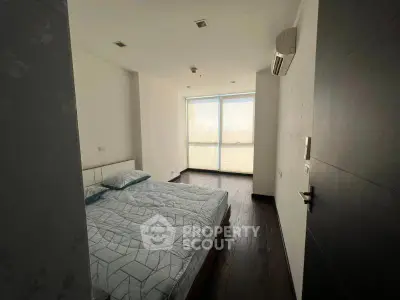 Cozy bedroom with large window and modern decor, perfect for relaxation and comfort.