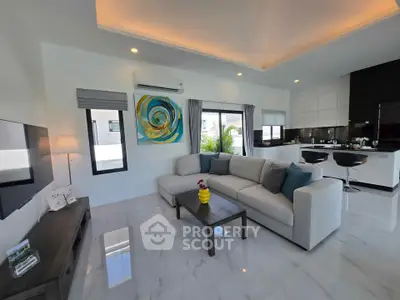Modern living room with open kitchen, featuring sleek design and stylish decor.