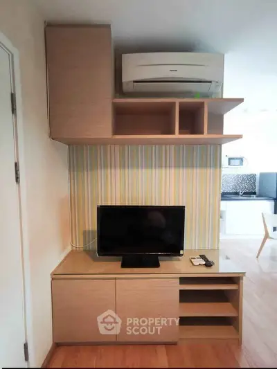 Modern living room with stylish TV cabinet and air conditioning unit, featuring sleek wooden furniture and vibrant wallpaper.