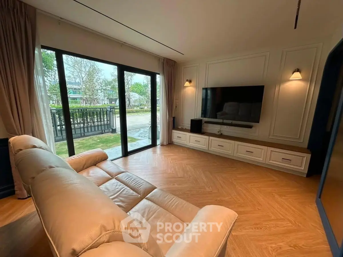 Spacious living room with elegant design and large windows overlooking a serene garden view.