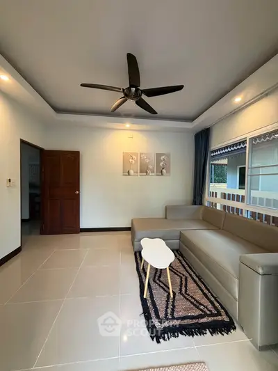 Spacious living room with modern ceiling fan and stylish sectional sofa