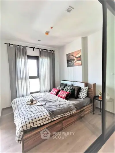 Modern bedroom with stylish decor and natural light in a cozy apartment.