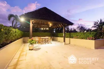 Stunning outdoor patio with gazebo and lush greenery at sunset, perfect for relaxation.