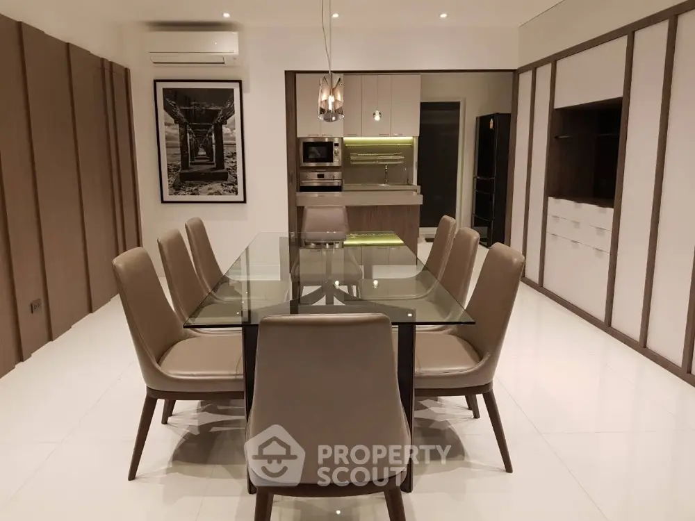Modern dining room with glass table and sleek kitchen design