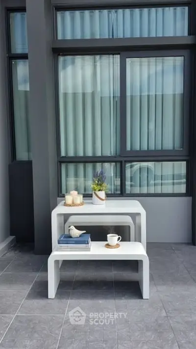 Modern outdoor patio with stylish furniture and large windows, perfect for relaxation and entertaining.