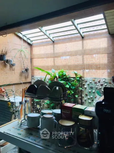 Charming kitchen with garden view and natural light, featuring a cozy tea setup and modern appliances.