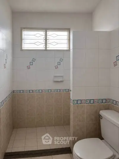 Charming bathroom with tiled walls and walk-in shower in cozy home.