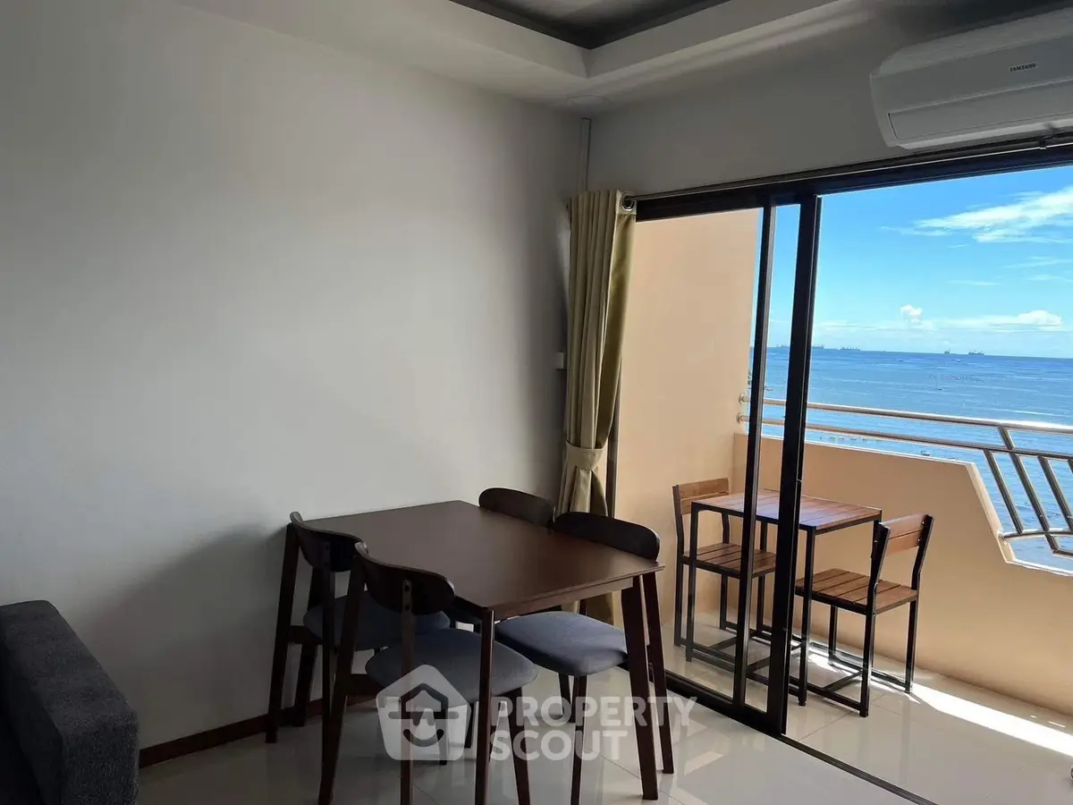 Charming seaside apartment with balcony offering stunning ocean views, perfect for dining and relaxation.