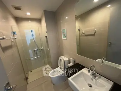 Modern bathroom with glass shower and sleek fixtures in a contemporary apartment.