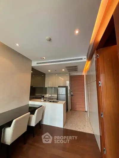 Modern kitchen with sleek design, featuring an open layout and stylish dining area.