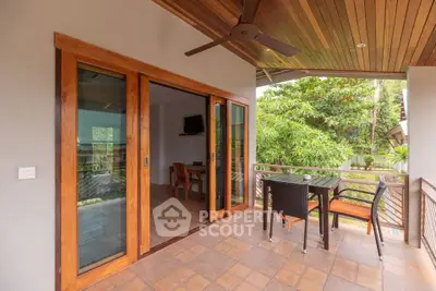 Charming balcony with wooden ceiling and lush garden view, perfect for relaxation.
