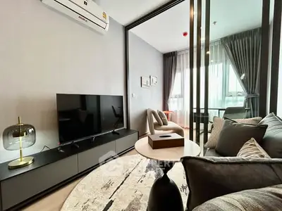 Modern living room with sleek furniture and large TV in stylish apartment.