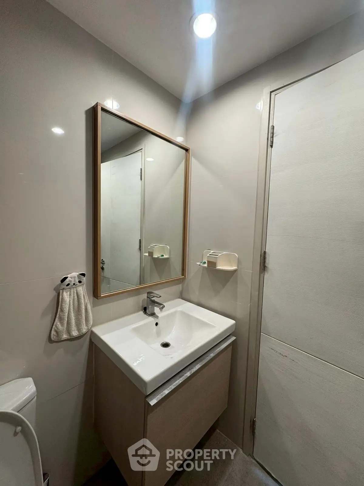 Modern bathroom with sleek vanity and mirror in a contemporary apartment.