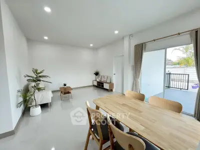Spacious modern living room with open layout and natural light, featuring stylish furniture and access to outdoor balcony.