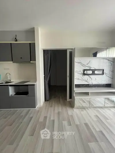 Modern kitchen with sleek cabinetry and marble accent wall