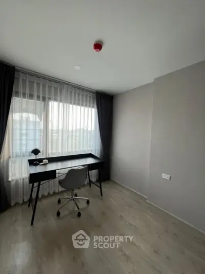 Modern study room with sleek desk and chair, large window with curtains, and minimalist decor.