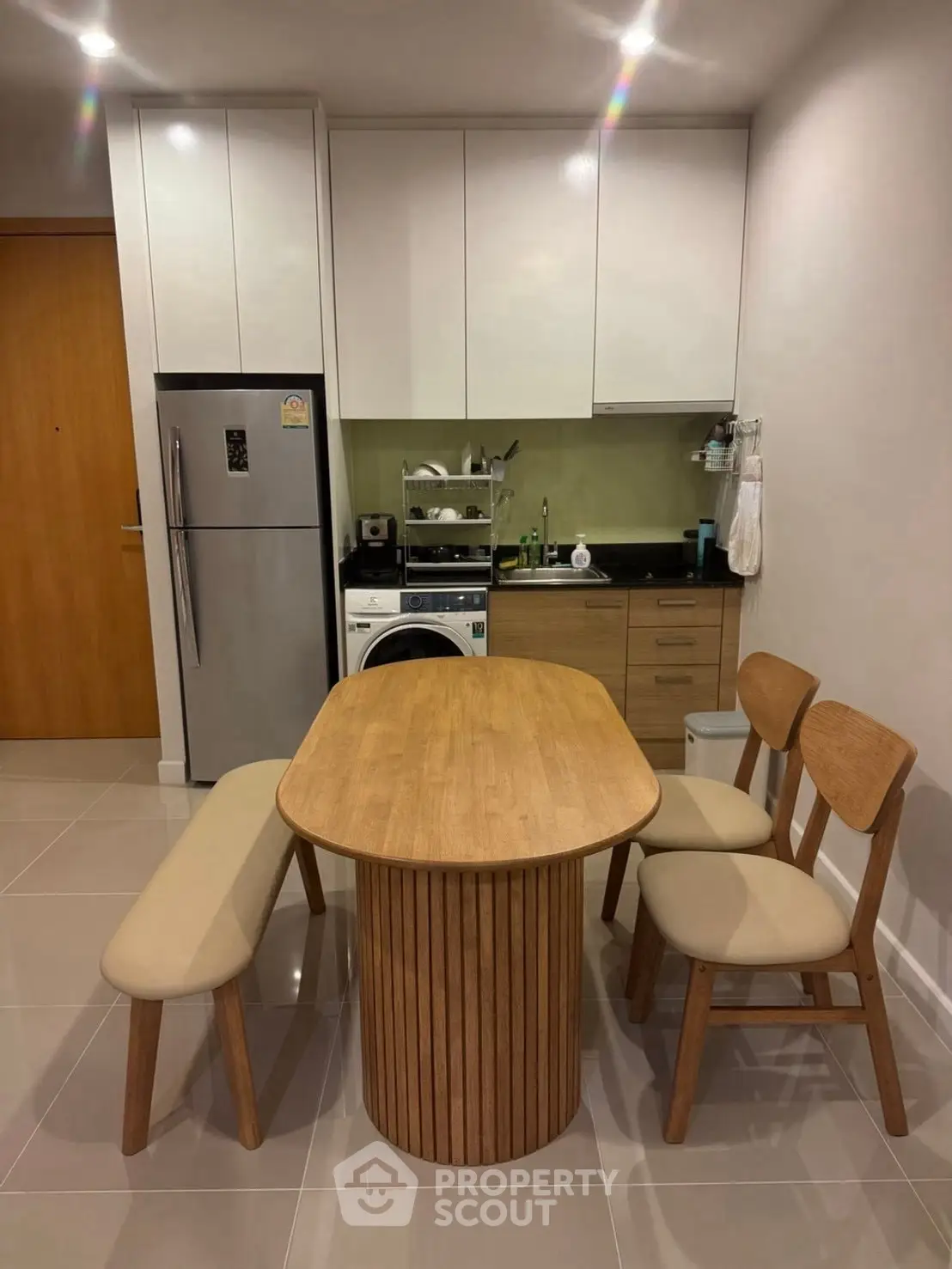 Modern kitchen with wooden dining set and compact appliances