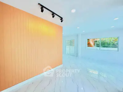 Spacious modern living room with marble flooring and large windows for natural light.