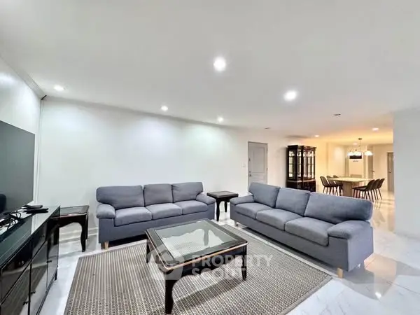 Spacious modern living room with elegant furniture and open dining area.