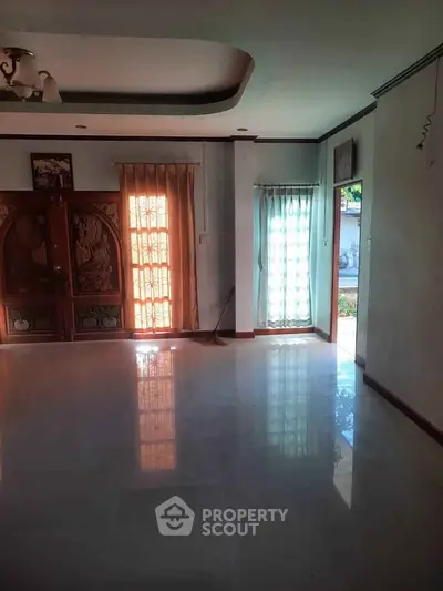 Spacious living room with elegant wooden doors and natural light