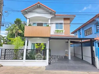 Charming two-story house with modern facade and spacious carport in a serene neighborhood.
